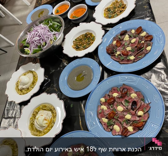 מנות שף מגוונות על שולחן, כולל סלטים ומנות בשר.